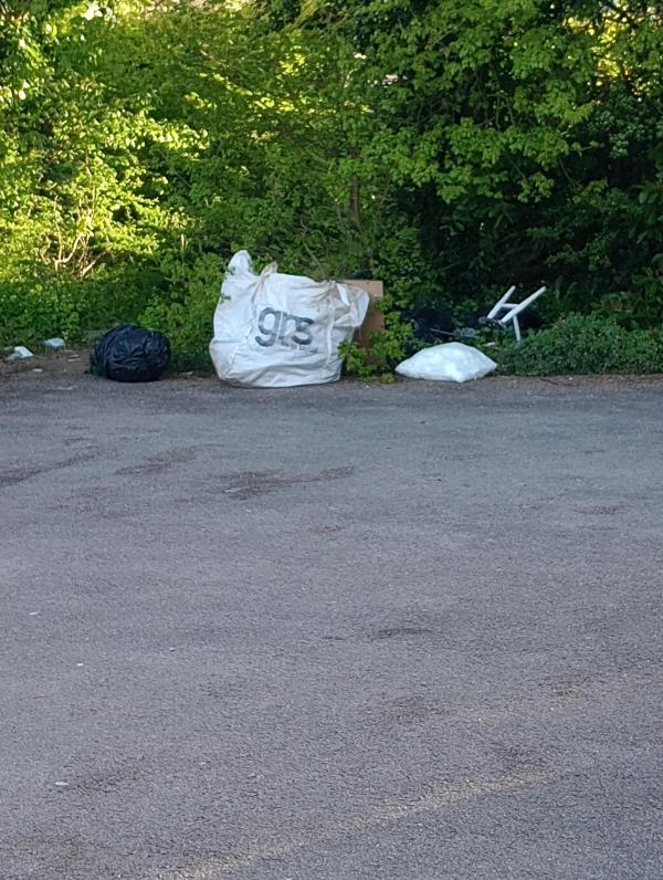 There is a big pile of rubbish left on the side of residential car park. -14 Blackthorn Drive, Leicester, LE4 1BH