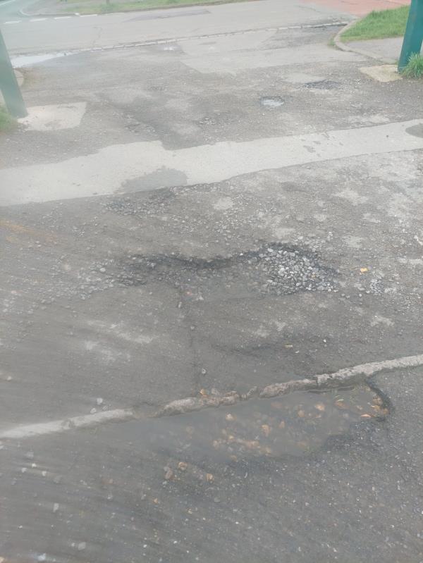 Potholes at the entrance to Church End Lane car park-85 Church End Lane, Tilehurst, Reading, RG30 4UW