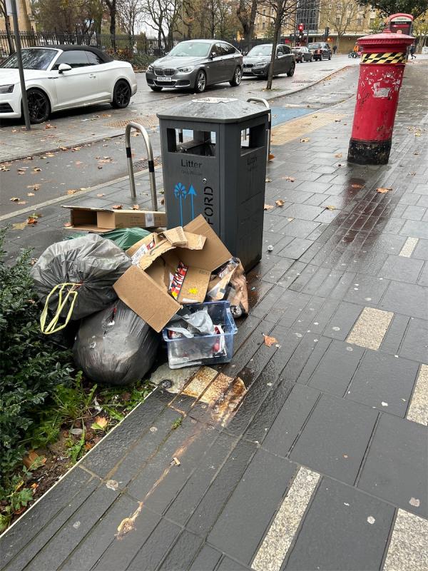 Piles of rubbish by the litter bin outside 57 Broadway-Global News, 55 Broadway, Stratford, London, E15 4BQ
