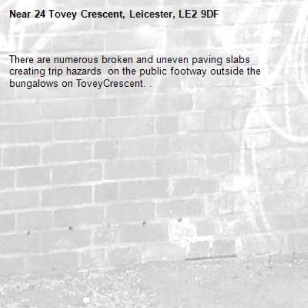 There are numerous broken and uneven paving slabs creating trip hazards  on the public footway outside the bungalows on ToveyCrescent. . -24 Tovey Crescent, Leicester, LE2 9DF
