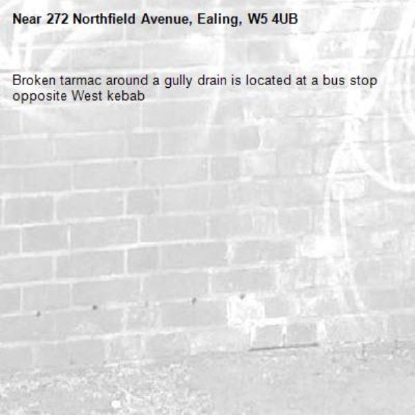 Broken tarmac around a gully drain is located at a bus stop opposite West kebab -272 Northfield Avenue, Ealing, W5 4UB
