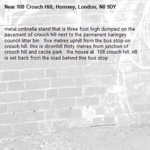 metal umbrella stand that is three foot high dumped on the pavement of crouch hill next to the permenent haringey council litter bin . five metres uphill from the bus stop on crouch hill. this is downhill thirty metres from junction of crouch hill and cecile park . the house at  108 crouch hill, n8 is set back from the road behind this bus stop-108 Crouch Hill, Hornsey, London, N8 9DY