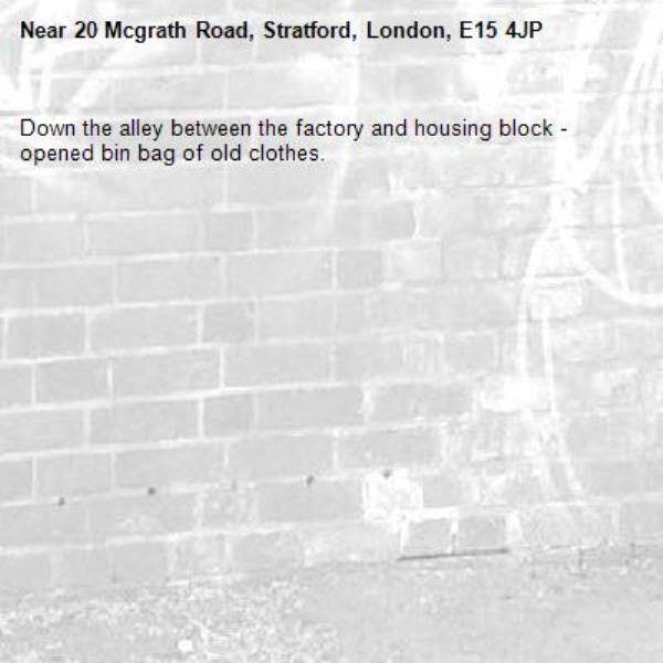 Down the alley between the factory and housing block - opened bin bag of old clothes.-20 Mcgrath Road, Stratford, London, E15 4JP