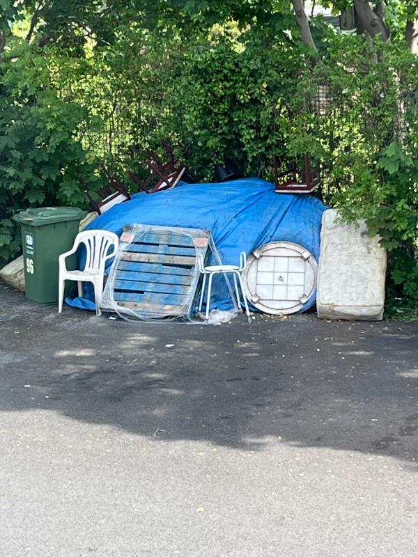 Pile of flytipped stuff is growing, with mattresses, chairs, pallet and more underneath tarpaulin -53 Fairlawn Park, London, SE26 5SA