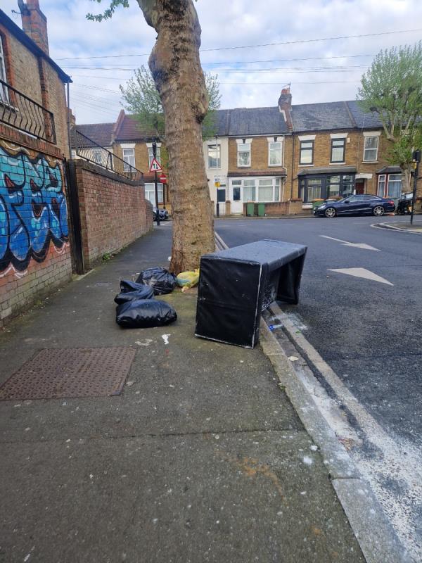 Sofa dumped on pavement by tree -62 Lansdown Road, Forest Gate, London, E7 8NE