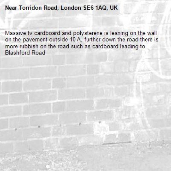 Massive tv cardboard and polysterene is leaning on the wall on the pavement outside 10 A, further down the road there is more rubbish on the road such as cardboard leading to Blashford Road -Torridon Road, London SE6 1AQ, UK