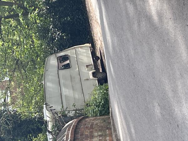 Abandoned caravan, broken and run down, in front of gates -Aylestone Meadows Access Road, Leicester