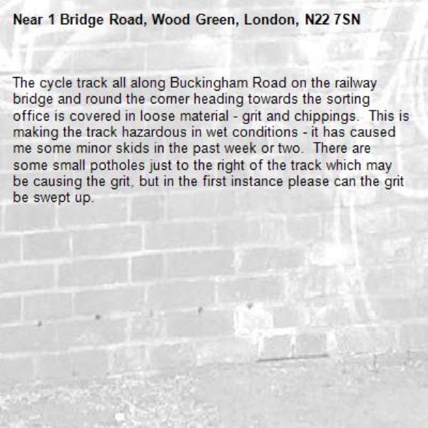 The cycle track all along Buckingham Road on the railway bridge and round the corner heading towards the sorting office is covered in loose material - grit and chippings.  This is making the track hazardous in wet conditions - it has caused me some minor skids in the past week or two.  There are some small potholes just to the right of the track which may be causing the grit, but in the first instance please can the grit be swept up.-1 Bridge Road, Wood Green, London, N22 7SN