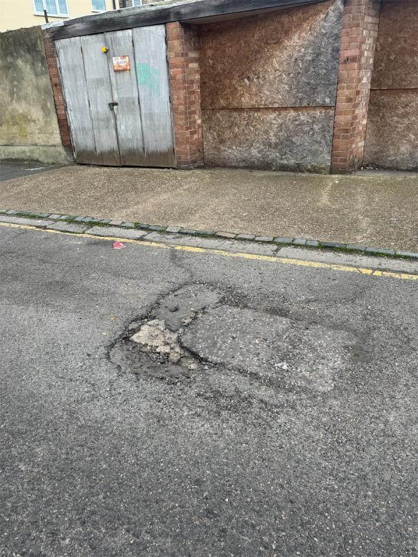 Large pothole opp 355 Dersingham o/s Garages **previously reported  in January 2024-355 Dersingham Avenue, Manor Park, London, E12 6JX