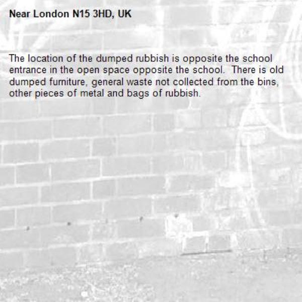 The location of the dumped rubbish is opposite the school entrance in the open space opposite the school.  There is old dumped furniture, general waste not collected from the bins, other pieces of metal and bags of rubbish.-London N15 3HD, UK