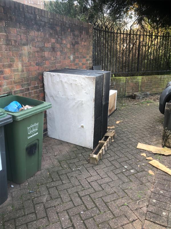 Please clear a bed base from parking area to side of block of flats-Maroons Way, Bellingham, London