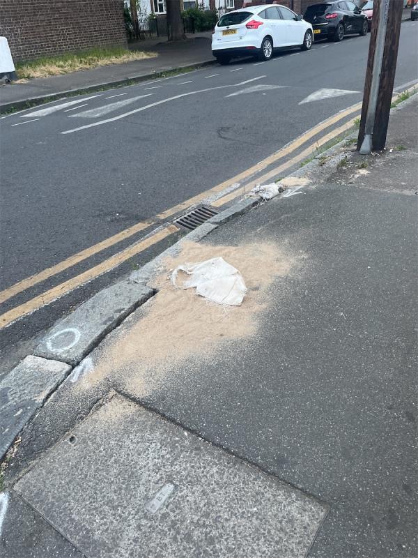 Repair needed to curb stone, sand bag dumped by contractor who made temporary repair -Metalwork Design Ltd, Strode Road, Forest Gate, London, E7 0DU