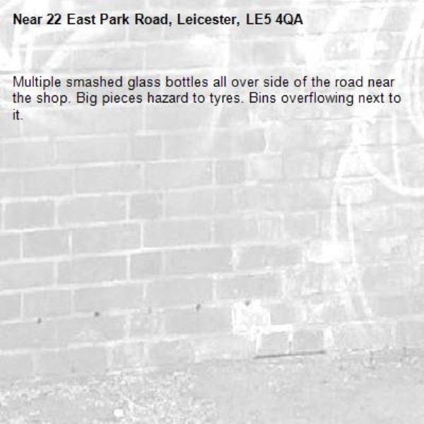 Multiple smashed glass bottles all over side of the road near the shop. Big pieces hazard to tyres. Bins overflowing next to it.-22 East Park Road, Leicester, LE5 4QA