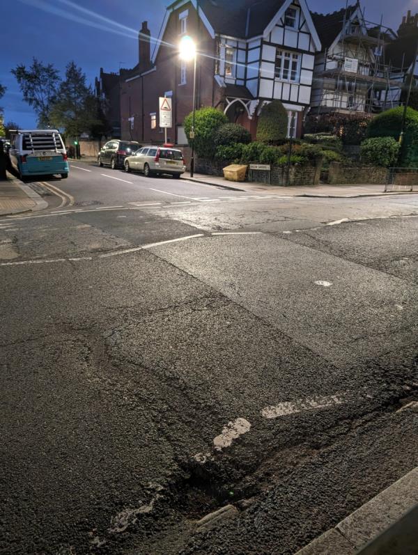 Several potholes on the edge of the road opposite Onslow Gardens. This whole bit of the road around bus stop C needs proper resurfacing. It's dangerous for busses, cars and cyclists.-2 Onslow Gardens, Hornsey, London, N10 3JU