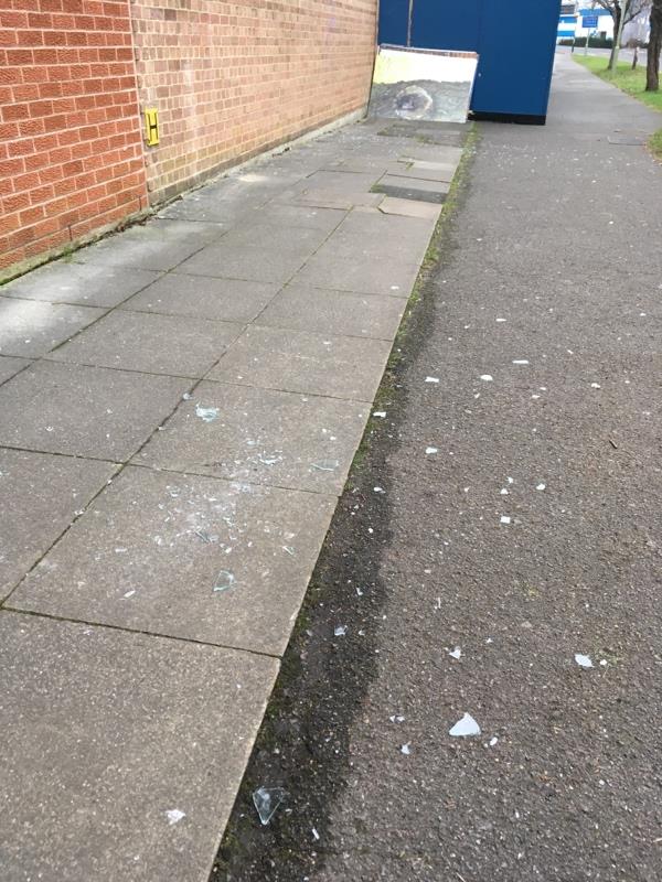 Broken glass all over the pavement behind the leisure centre. Smashed windows on top floor with loose glass. More could fall on pedestrians. Very dangerous.-Farnborough Library PINEHURST, Farnborough, GU14 7LD