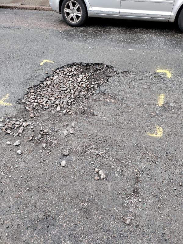 Pothole marked in road over a month ago. Truck came down the road and fixed others but left this one. 
Size is 1.5m x 1.5m and big stones being thrown out at cars-19 Dulverton Road, Leicester, LE3 0SB