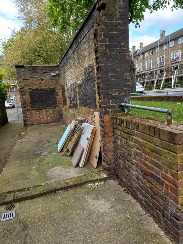 builders waste and internal doors left by the wall opposite the refuse bin chamber-33-44 Ivy Road