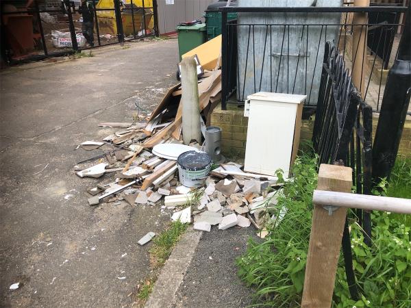 Please clear flytip of builders waste from bin area-Millcroft House, Melfield Gardens, London, SE6 3AJ