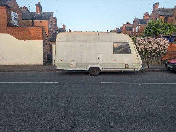 This caravan appears to be abandoned. It has a flat tyre and is unsecured as I believe the only thing stopping it from rolling is a single brick.-10 Compton Road, Leicester, LE3 2AA