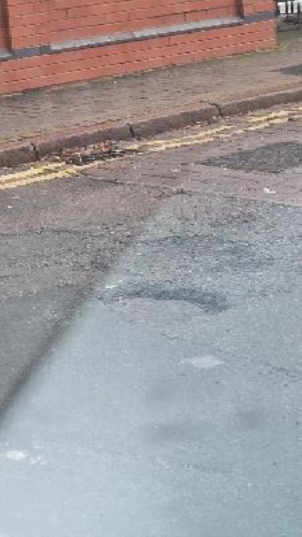 pothole on entry to road -6a Ross Walk, Latimer, LE4 5HH, England, United Kingdom