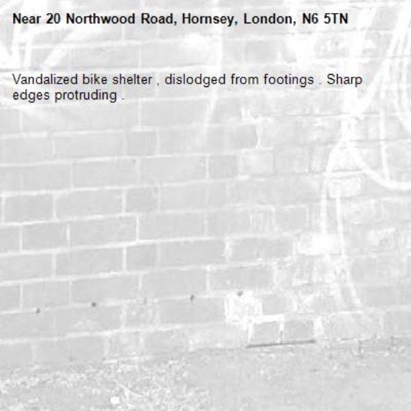 Vandalized bike shelter , dislodged from footings . Sharp edges protruding . -20 Northwood Road, Hornsey, London, N6 5TN