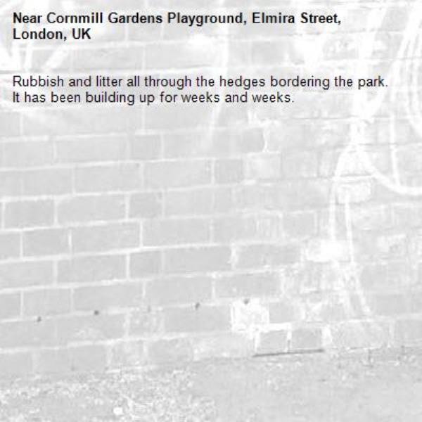 Rubbish and litter all through the hedges bordering the park.  It has been building up for weeks and weeks.-Cornmill Gardens Playground, Elmira Street, London, UK