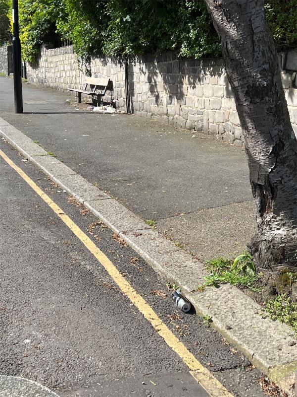 Empty beer cans and various items scattered around the bench but also in the street and by the gate-25D, Bonfield Road, Lewisham, London, SE13 6BY
