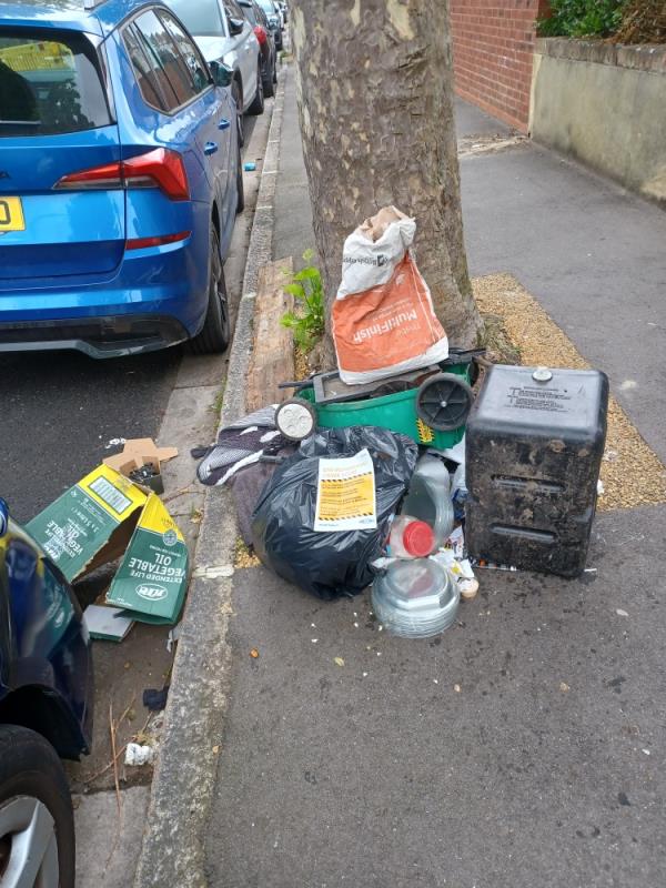 Building and household waste fly tipped underneath a tree at 86 Chester Road, E7. -86 Chester Road, Forest Gate, London, E7 8QS