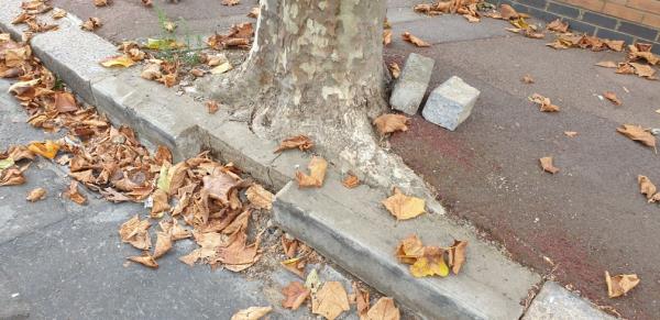 Broken kerb by the tree is damaging car rims and tyres -28 Dorset Road, Green Street East, E7 8PS