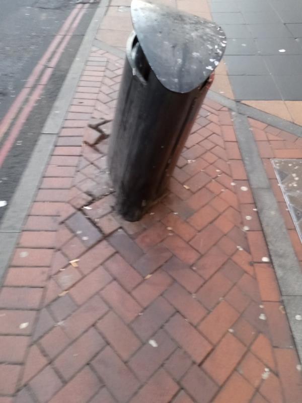 Litter bin has been dislodged and leaning to one side due to some kind of vehicle accident which has lifted the pavement. -30-31 Friar Street, RG1 1DX, England, United Kingdom