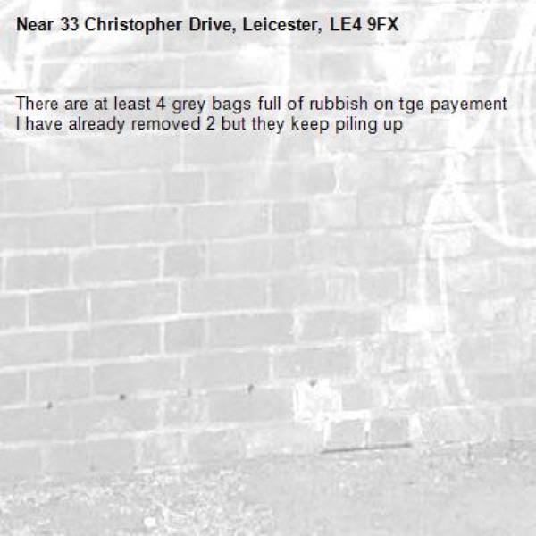 There are at least 4 grey bags full of rubbish on tge payement I have already removed 2 but they keep piling up-33 Christopher Drive, Leicester, LE4 9FX