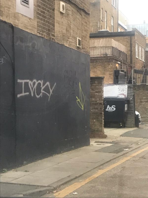 Silver and yellow spray painted tags are located on a black painted wall on Canberra Road behind 87 Broadway W13-87 BROADWAY, West Ealing, W13 9BP