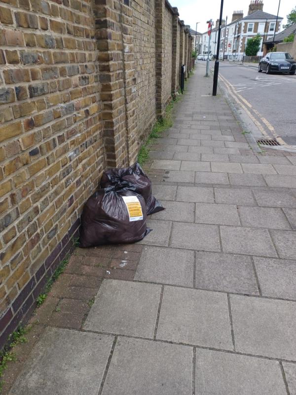 Bags containing items of clothing fly tipped at junction of 99 Chesterton Road and Herbert Street, E13. -99 Chesterton Road, Plaistow, London, E13 8BD