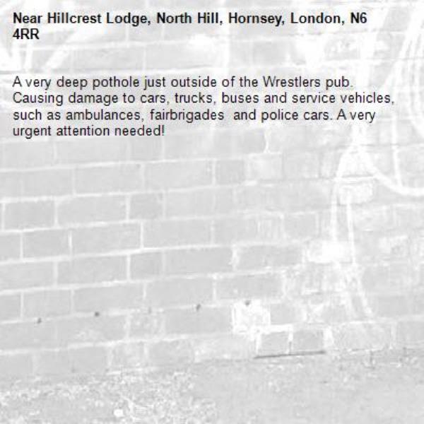 A very deep pothole just outside of the Wrestlers pub. Causing damage to cars, trucks, buses and service vehicles, such as ambulances, fairbrigades  and police cars. A very urgent attention needed! -Hillcrest Lodge, North Hill, Hornsey, London, N6 4RR