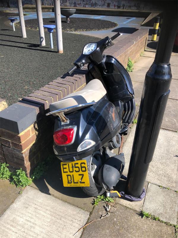 At entrance to  Parking area by Lamppost H2435
Eu56Dlz PIAGGIO Motor bike. Front wheel is missing. Vehicle is chained to Post-Lapwing Tower, Taylor Close, Deptford, London, SE8 5UH