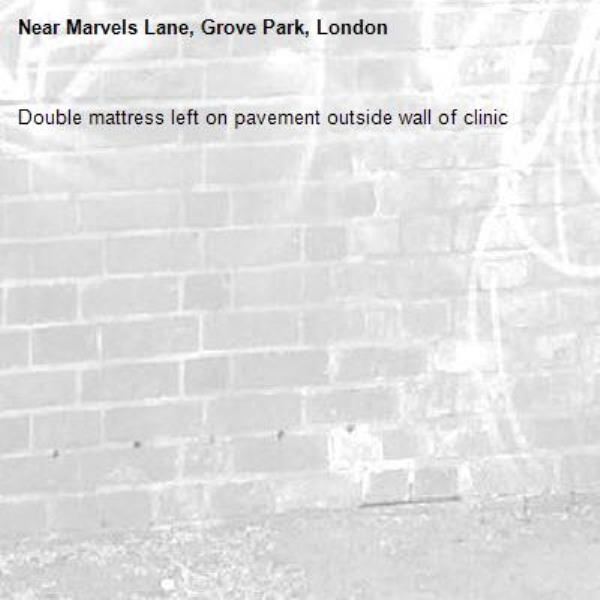Double mattress left on pavement outside wall of clinic-Marvels Lane, Grove Park, London