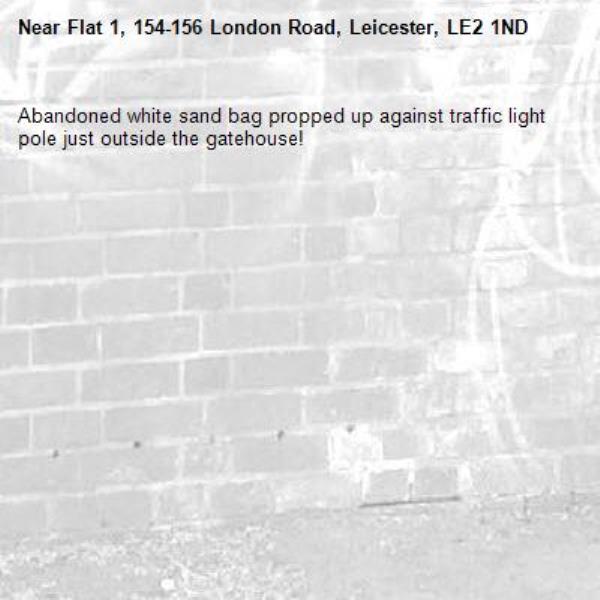 Abandoned white sand bag propped up against traffic light pole just outside the gatehouse! -Flat 1, 154-156 London Road, Leicester, LE2 1ND