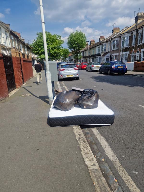 Mattress and rubbish dumped on pavement by tree -62 Lansdown Road, Forest Gate, London, E7 8NE