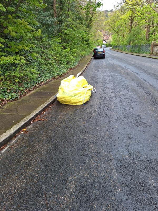 Large yellow builders bag in road filled with green waste and some rubble 
Please can you clear thanks -Cherry Garden Road, Downside, Eastbourne