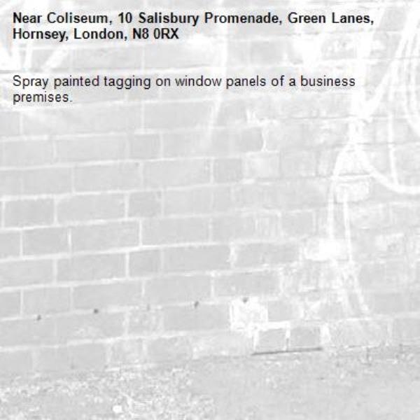 Spray painted tagging on window panels of a business premises.-Coliseum, 10 Salisbury Promenade, Green Lanes, Hornsey, London, N8 0RX