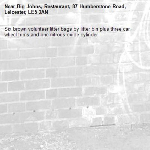 Six brown volunteer litter bags by litter bin plus three car wheel trims and one nitrous oxide cylinder -Big Johns, Restaurant, 87 Humberstone Road, Leicester, LE5 3AN