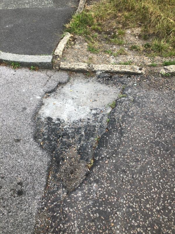 Side of 25-35 Evans  Road. Pot hole at start of service road-29 Evans Road, London, SE6 1QG