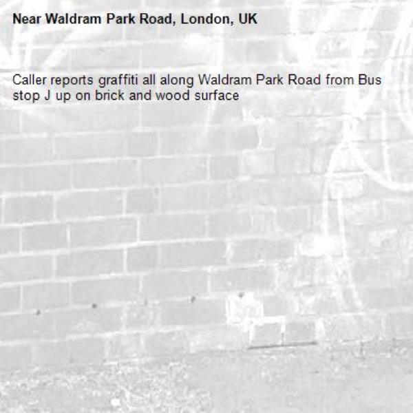Caller reports graffiti all along Waldram Park Road from Bus stop J up on brick and wood surface-Waldram Park Road, London, UK