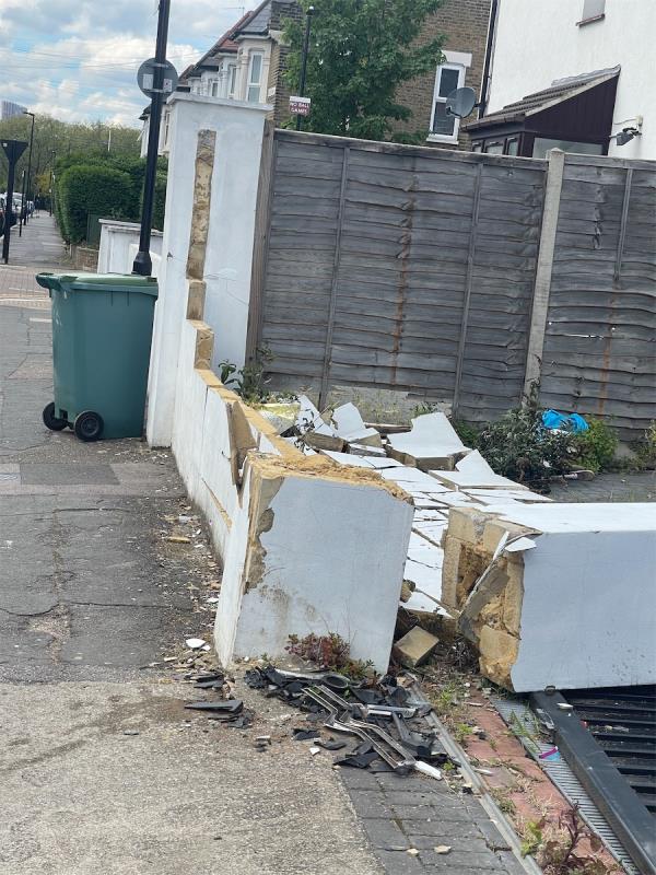 Broken wall sticking out and debris over pavement weeks after damaging -73 Boleyn Road, Forest Gate, London, E7 9QD