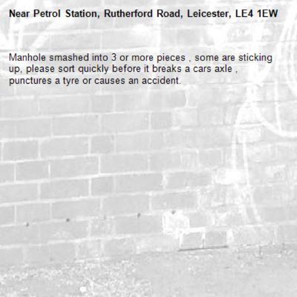Manhole smashed into 3 or more pieces , some are sticking up, please sort quickly before it breaks a cars axle , punctures a tyre or causes an accident.-Petrol Station, Rutherford Road, Leicester, LE4 1EW
