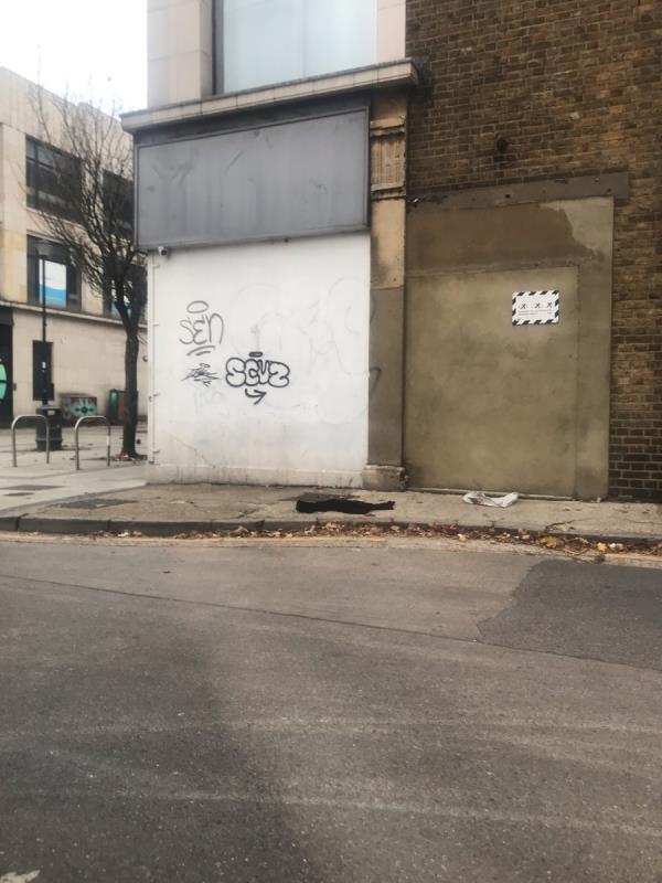 Black spray painted tags are located on a white painted wall located on Canberra Road junction St James’s Avenue W13-99-103 BROADWAY, West Ealing, W13 9BP
