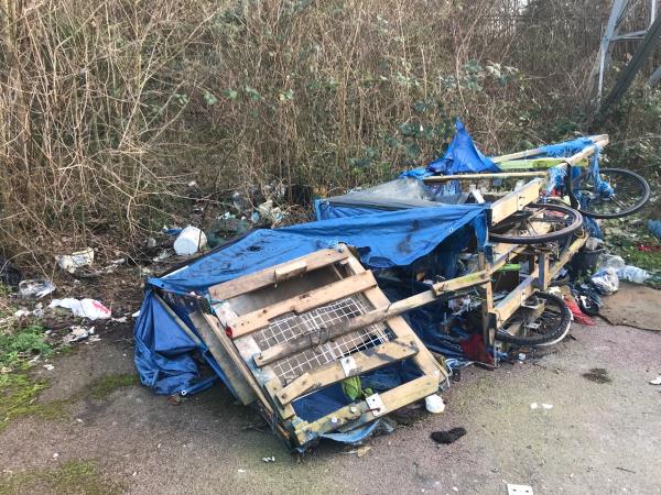 Under pylon off path between Winsor Terrace and DLR line.fly tipping including a scrap broken homemade wheeled vehicle and other items. Also a trolley. -2 Winsor Terrace, Beckton, E6 6LE, England, United Kingdom