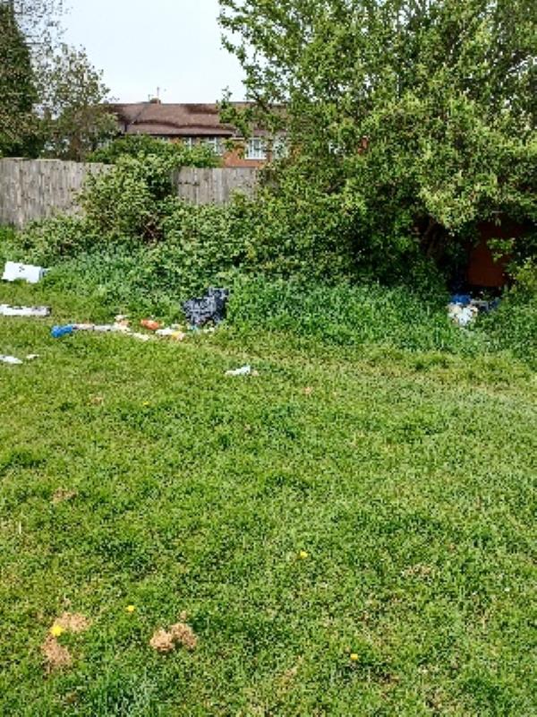 bags of household waste dumped in bushes and on green near Swainson Road entrance.  rear of Brighton Road NC-3 Swainson Road, Leicester, LE4 9DR