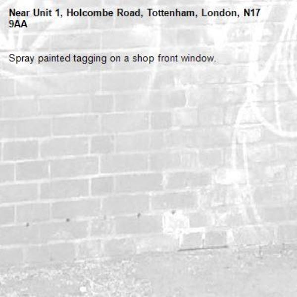 Spray painted tagging on a shop front window.-Unit 1, Holcombe Road, Tottenham, London, N17 9AA