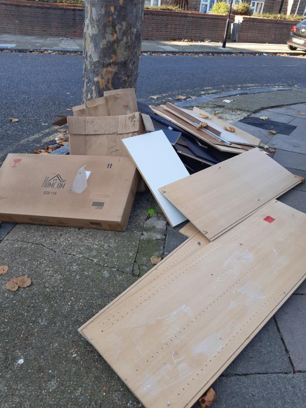 Cardboard boxes and dismantled units dumped by the tree near 21 Jones Road junction with Holborn Road E13 -21 Jones Road, Plaistow South, E13 8NX, England, United Kingdom